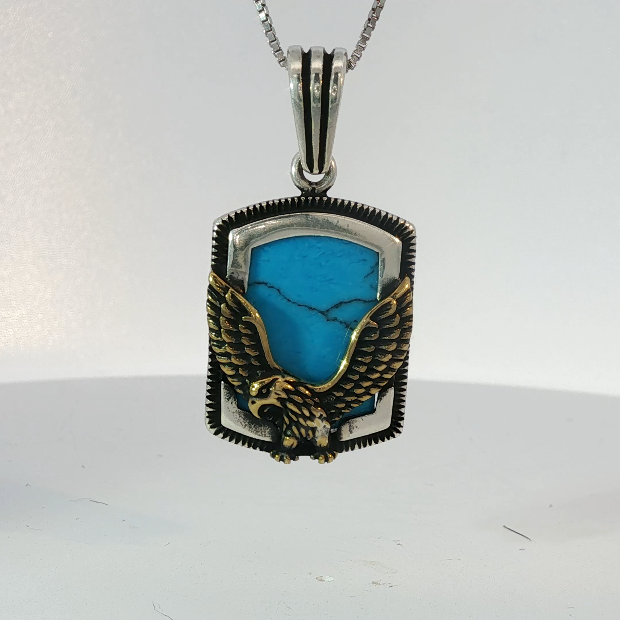 Silver Pendant Featuring Emerald Cut Blue Turquoise Gemstone with Plated Yellow Gold Eagle Design