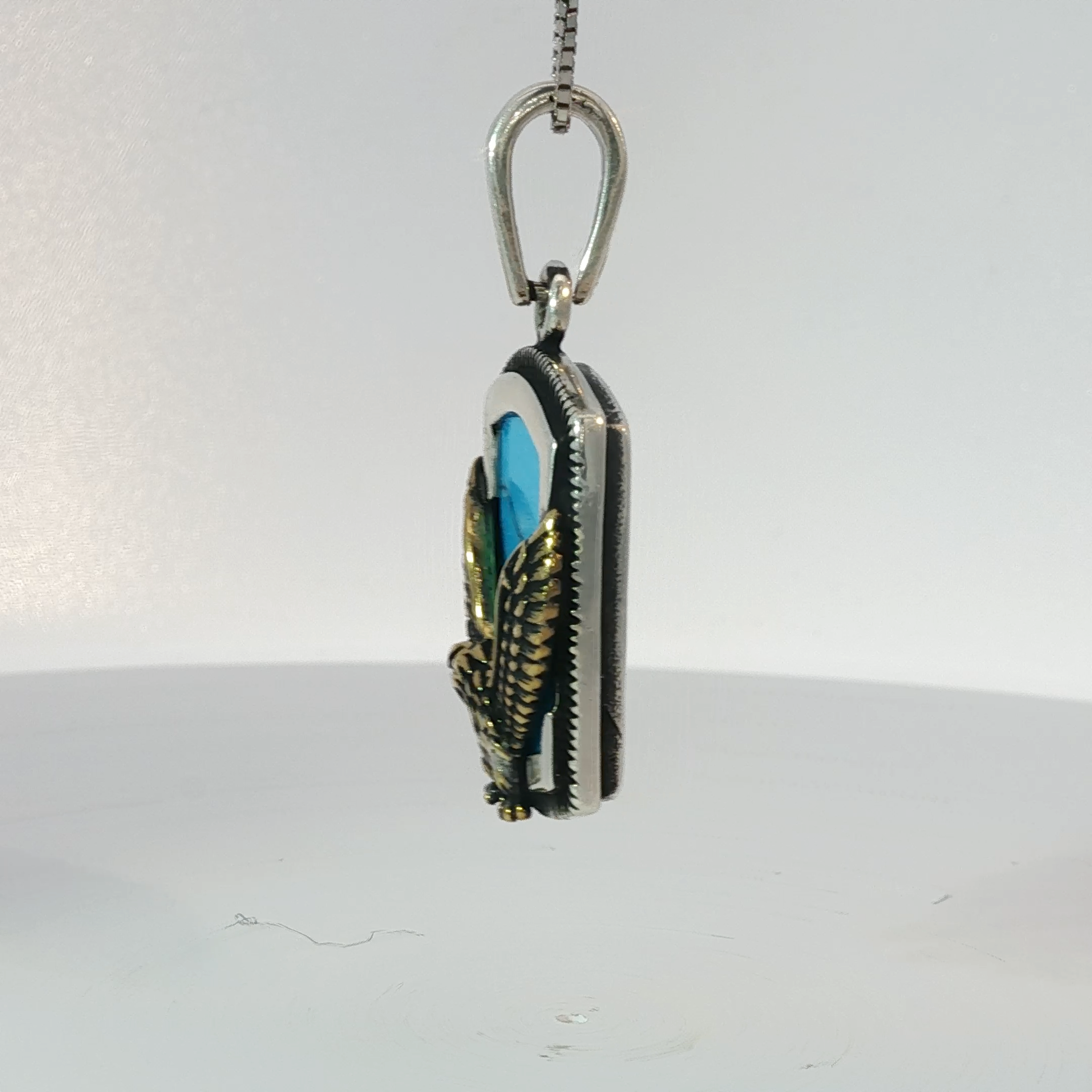 Silver Pendant Featuring Emerald Cut Blue Turquoise Gemstone with Plated Yellow Gold Eagle Design